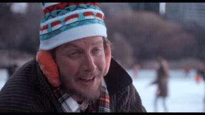 Man In Colorful Hat And Ear Muffs Looking At Camera GIF