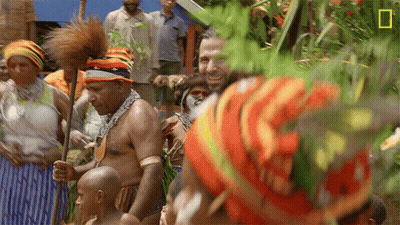 Man In Colorful Hat In Crowd With National Geographic Logo GIF