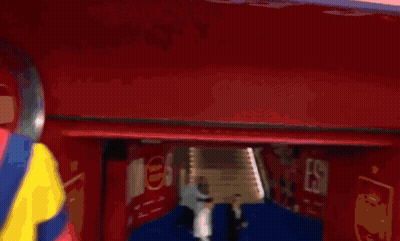 Man In Colorful Jacket In Front Of Coke Sign GIF