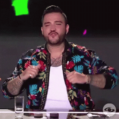 Man In Colorful Jacket Sitting At Table GIF