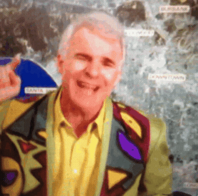 Man In Colorful Jacket Smiling In Front Of Downtown Map GIF