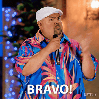 Man In Colorful Shirt Holding Microphone With Bravo Above GIF