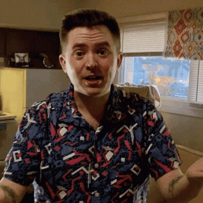 Man In Colorful Shirt Making Funny Face In Front Of Window GIF