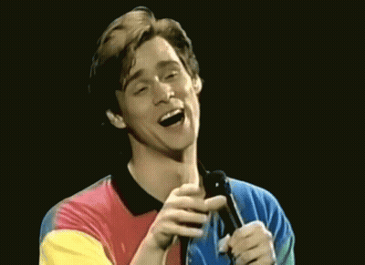 Man In Colorful Shirt Singing Into Microphone And Laughing GIF