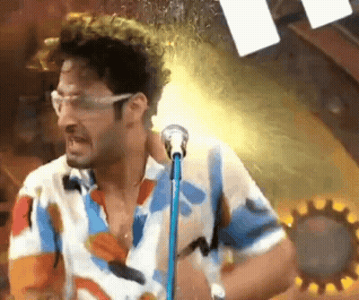 Man In Colorful Shirt Singing Into Microphone GIF