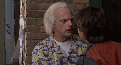 Man In Colorful Shirt Talking To Another Man In Front Of Brick Wall GIF