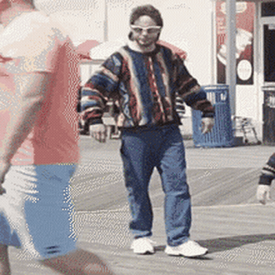 Man In Colorful Sweater And Sunglasses On Boardwalk GIF
