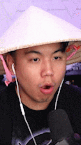 Man In Conical Hat Talking Into Microphone GIF