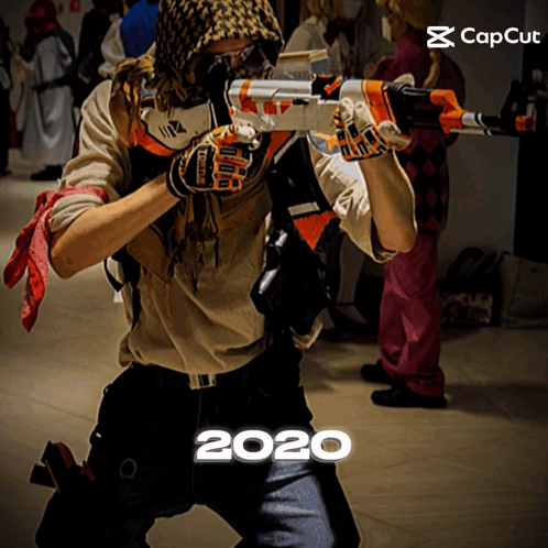 Man In Costume Holding Gun With Year 2020 Below GIF