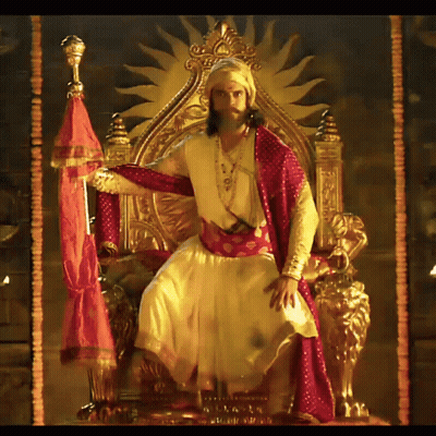 Man In Costume On Throne With Sun GIF