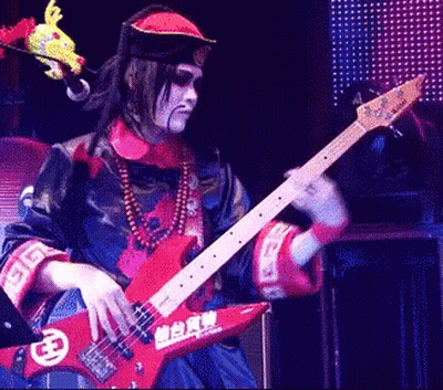 Man In Costume Playing Guitar With Chinese Characters GIF