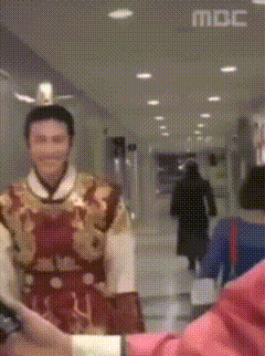 Man In Costume Standing In Hallway With MBC On Ceiling GIF