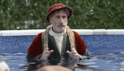 Man In Costume Standing In Pool With Snake Around Neck GIF