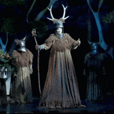 Man In Costume With Antlers Standing Next To Another Man GIF