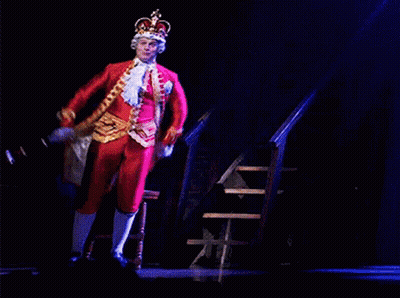 Man In Costume With Crown Sitting On Chair GIF