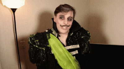 Man In Costume With Green Sash GIF