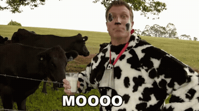 Man In Cow Costume Holding Glass Of Milk GIF