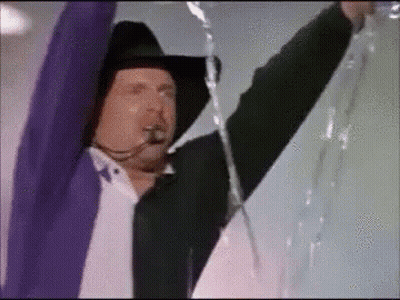 Man In Cowboy Hat And Purple Jacket Holding Rope GIF
