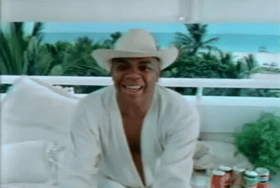 Man In Cowboy Hat And Robe Sitting On Balcony GIF