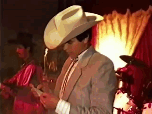 Man in Cowboy Hat and Suit on Phone