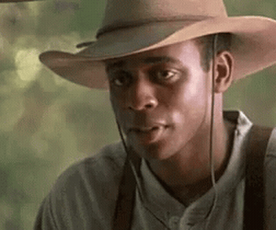 Man In Cowboy Hat And Suspenders Looking Sideways GIF