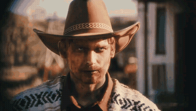 Man In Cowboy Hat And Sweater In Front Of Building GIF