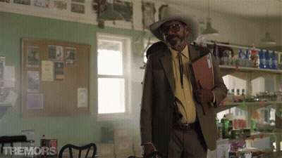 Man in Cowboy Hat Holding Folder With Tremors Sign