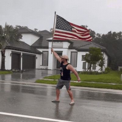Man In Cowboy Hat Holding Large American Flag GIF