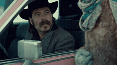 Man In Cowboy Hat Looking Out Pink Car Window GIF