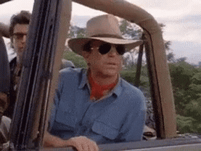 Man In Cowboy Hat Lying On Dinosaur GIF