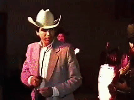 Man In Cowboy Hat Pink Jacket Dark Room GIF