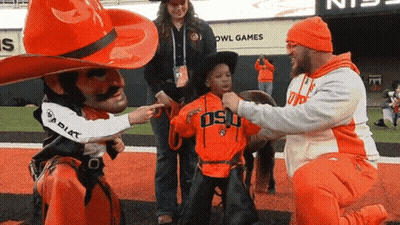 Man In Cowboy Hat Pointing At Child In Osu Shirt GIF
