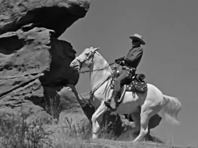 Man In Cowboy Hat Riding Horse On Rocky Hillside GIF