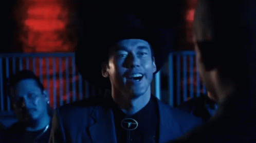 Man In Cowboy Hat Standing Before Home Sign GIF