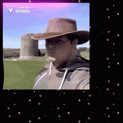 Man In Cowboy Hat Taking Selfie In Front Of Castle GIF