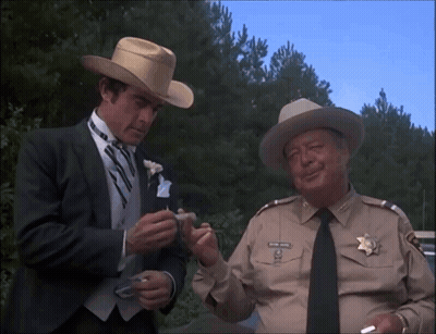 Man In Cowboy Hat Talking To Man In Suit GIF
