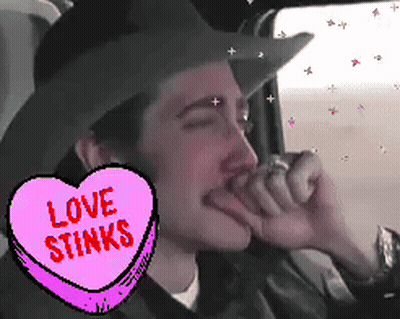 Man In Cowboy Hat With Love Stinks Heart GIF