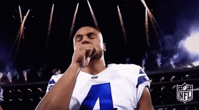Man In Cowboys Jersey Blowing Kiss In Front Of Fireworks GIF