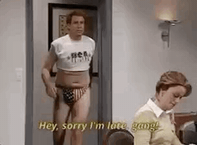 Man In Crop Top And Swim Trunks Standing In Doorway Next To Woman GIF