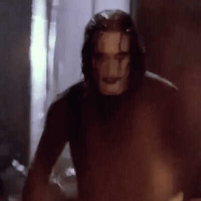 Man In Crow Mask Standing In Dark Room GIF