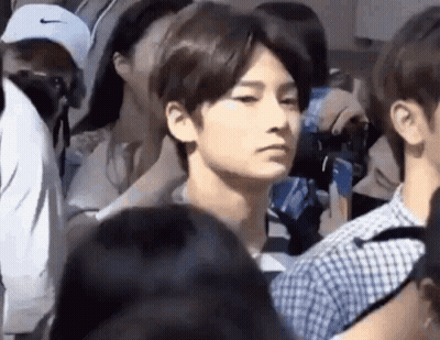 Man In Crowd Looking At Camera GIF
