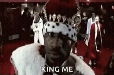 Man In Crown And Fur Coat Saying King Me On Red Carpet GIF