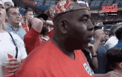 Man In Crown And Red Shirt Standing In Crowd GIF