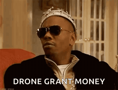 Man In Crown And Sunglasses On Couch Says Drone Grant Money GIF