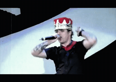 Man In Crown Holding Microphone In Mouth GIF