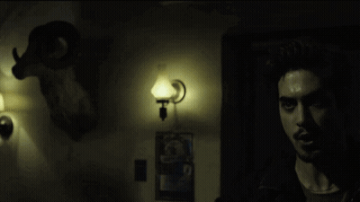 Man In Dark Room With Glowing Eyes GIF