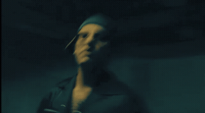 Man In Dark Room With Light On Shoulder GIF