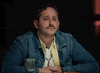 Man In Denim Jacket At Table With Water GIF