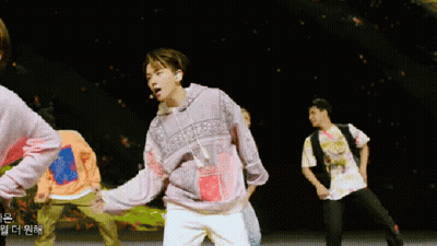 Man In Denim Jacket Dancing In Front Of Netflix Sign GIF