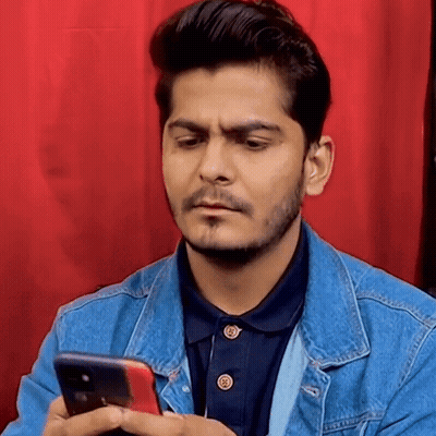 Man In Denim Jacket Holding Cell Phone Making Funny Face GIF